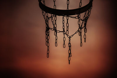 Low angle view of basketball hoop against sky during sunset