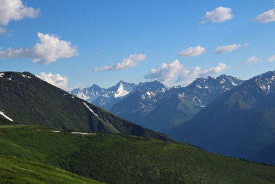 Green mountains and mountain range with snow-capped peaks on the karatyurek pass in altai in summer