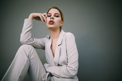 Portrait of a young woman against gray background