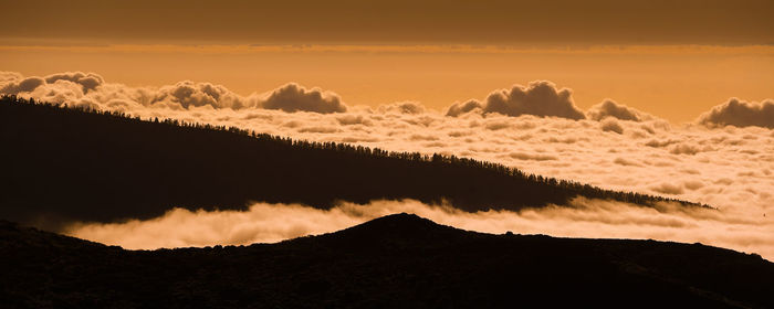 Beautiful panorama view of mountain and trees with impressive clouds at the sunset. 