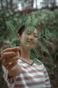 Close-up of woman holding leaves