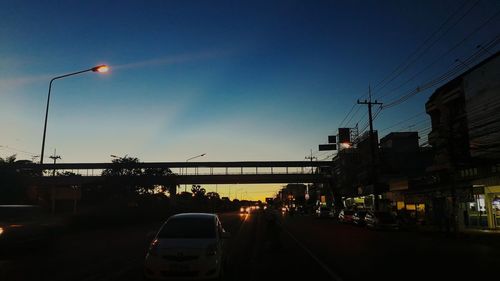 Cars on road against sky during sunset