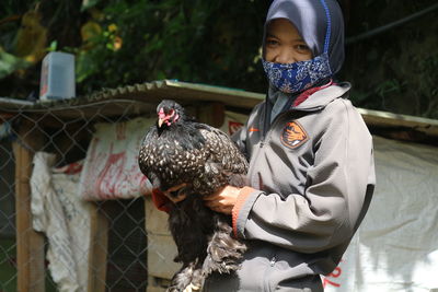 Rear view of young woman standing in cage