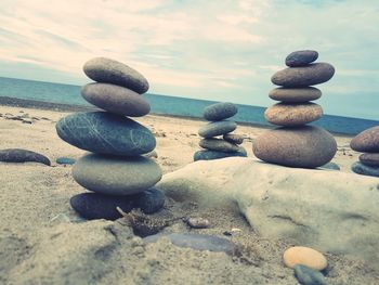 Stack of pebbles on beach against sky