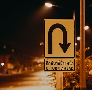 Close-up of road sign at night