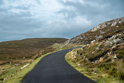 Empty road along landscape against sky