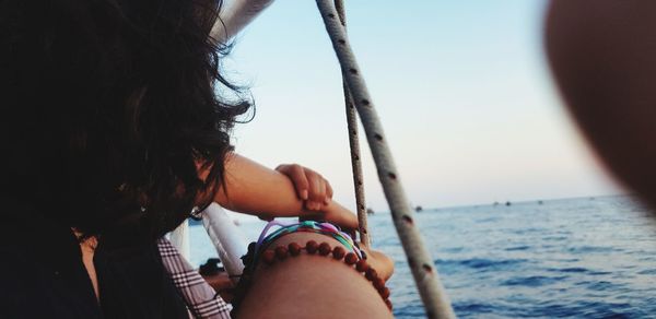 Midsection of woman holding sea against sky