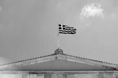 Low angle black and white view of greek flag against sky