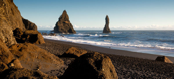 Panoramic view of rocks on beach against sky