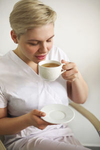 Mid section of a woman with coffee cup