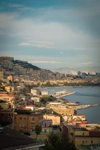 High angle view of townscape by sea against sky