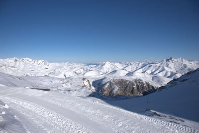 Scenic view of snowcapped mountains against clear blue sky