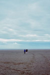 People on beach against sky