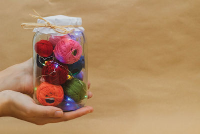 High angle view of woman holding multi colored flower on table