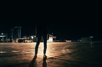 Rear view of man on illuminated city at night