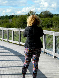 Rear view of woman standing against trees