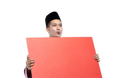 Portrait of young man standing against white background