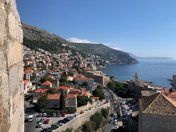 High angle view of townscape by sea against clear sky