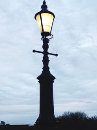 Low angle view of street light against cloudy sky