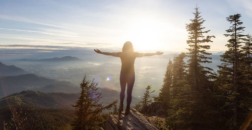 Rear view of woman standing on land against sky