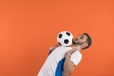 Rear view of soccer ball against yellow background