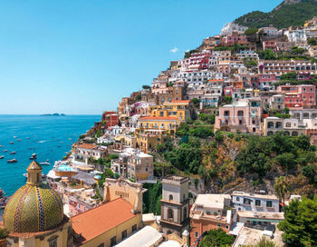 High angle view of townscape by sea against clear sky