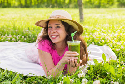 Portrait of a smiling young woman in drinking glass