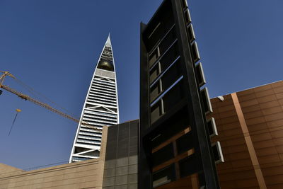 Low angle view of modern buildings against clear blue sky