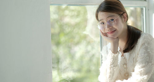 Portrait of a girl with glasses sitting by the window in a restaurant.