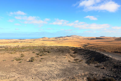 Scenic view of arid landscape against sky