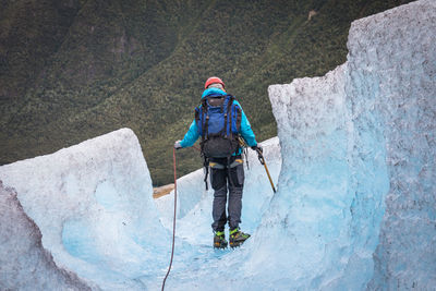 Rear view of hiker on glacier