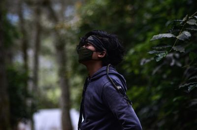 Side view of young woman in forest