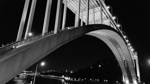 Low angle view of illuminated bridge against sky at night