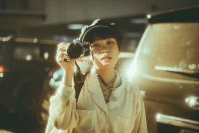 Portrait of young woman photographing camera