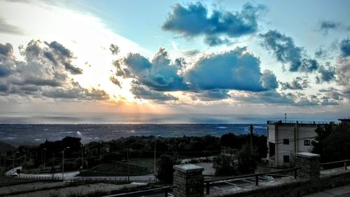 Panoramic view of sea and town against cloudy sky