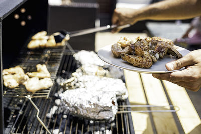 Spicy chicken wings grilling on a summer barbecue.