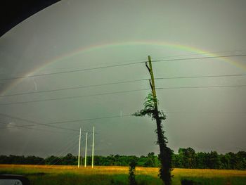 Electricity pylon against cloudy sky