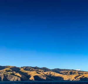 Scenic view of mountains against clear blue sky