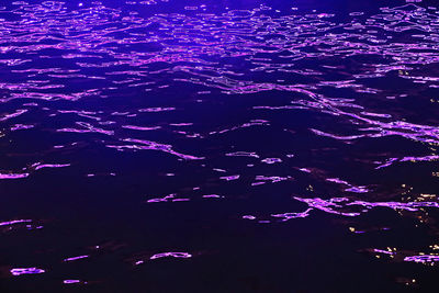 High angle view of illuminated sea at night