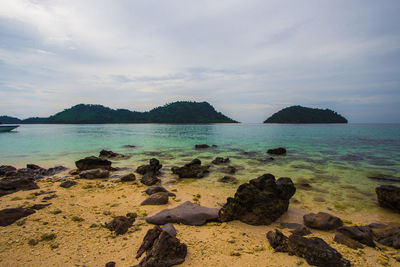 Rocks on sea shore against sky