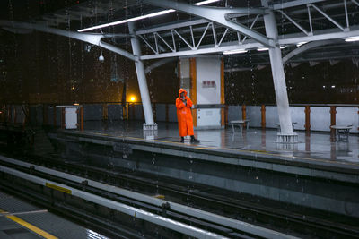 Man standing on railroad station platform during rainy season