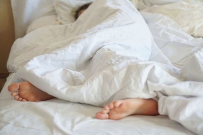 Midsection of baby sleeping in bed