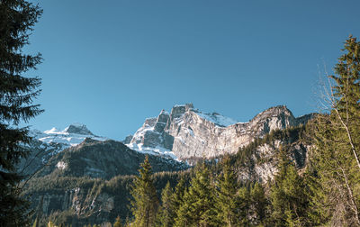 Low angle view of snowcapped mountains against clear sky