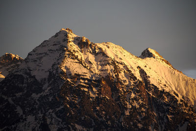 Low angle view of rocky mountains against clear sky