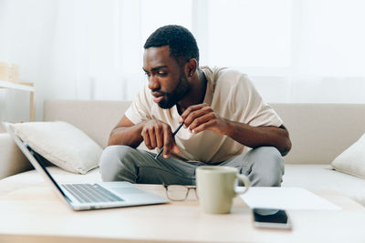 Young man using laptop at home