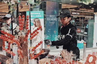 Young man looking through glass window at store