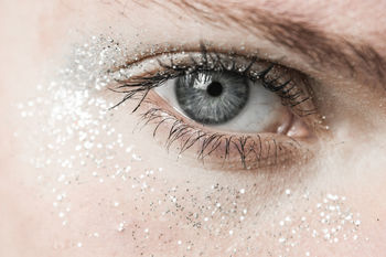 Close-up portrait of woman gray eyes with shimmer make-up