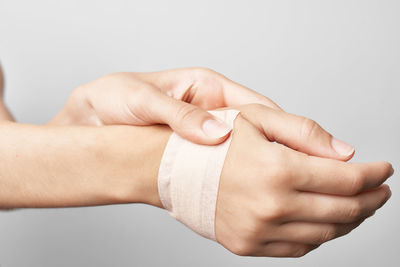 Close-up of hand holding hands over white background