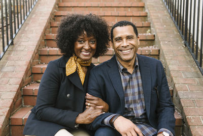 Portrait of happy couple sitting on steps