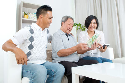 Family calculating paper currency at home